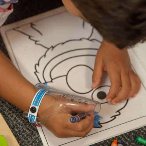 a child drawing a picture, wearing Aerothumb