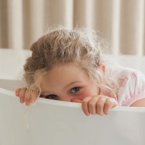 girl looking over the side of a bath